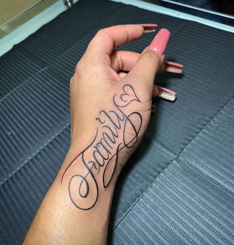 Family Hand Tattoo For Women, Name Tattoo On Forearm For Women, Hand Tattoos Names, Name Hand Tattoos For Women, Side Hand Tattoos Words, Hand Tattoos For Women Words, Name Tattoo On Buttcheek, Hand Word Tattoos, Cursive Hand Tattoo