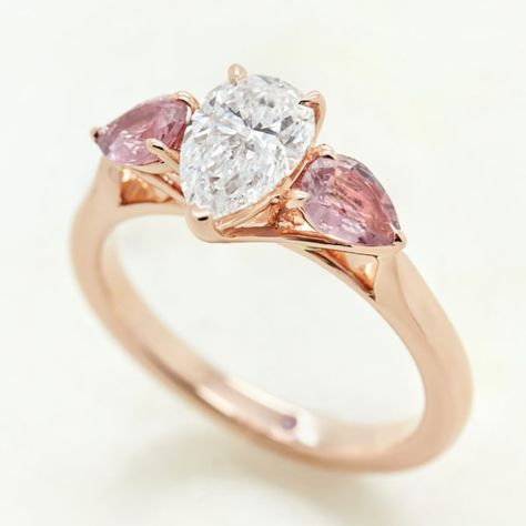 pear diamond rose gold trilogy engagement ring with pink pear sapphire accent stones Pear Trilogy Engagement Ring, Custom Sapphire Engagement Ring, Taylor Hart, Diamond Dress Ring, Trilogy Engagement Ring, Sapphire Engagement Rings, Peach Sapphire, Pink Sapphire Ring, Purple Sapphire