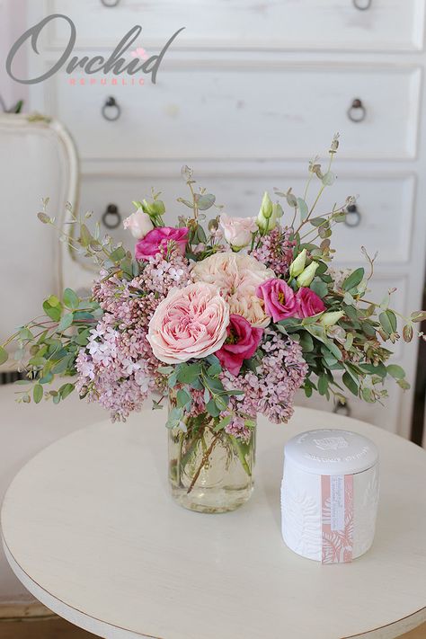 Simple yet stunning, this loose flower arrangement features fresh spring blooms, such as peonies in delicate swirls of blush, hot pink spray roses, clouds of lilacs, and buds of lisianthus bursting amidst a thicket of lush foliage. It is presented in a charming glass jar. Bride Bouquet Pink, Simple Floral Centerpieces, Pink Spray Roses, Pink Flower Arrangements, Spring Floral Arrangements, Blush Wedding Flowers, Flowers Bouquet Gift, Rose Arrangements, Simple Furniture