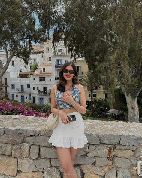 Throwback to a sunny May in Spain! 🇪🇸 Akshata’s grey leheriya halter neck top paired with a white flouncy skirt is the perfect combination of chic and carefree. Those Raybans and gold accessories complete the look. Style details: Top : @kajrakh Skirt: @hm Watch: @titanwatchesofficial Sunglasses: @rayban #spain #throwback #summerfashion #fashion #style #kajrakh #hm #titan #museandco Flouncy Skirt, Halter Neck Top, Gold Accessories, Bollywood Actress, Halter Neck, Muse, Sunnies, Mood Board, Ray Bans