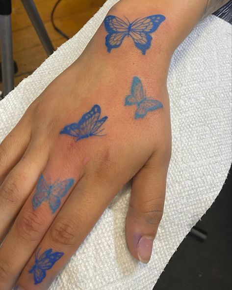 All Blue Tattoos For Women, Blue Butterfly Tattoo On Hand, Pretty Blue Tattoos, Blue Butterfly Hand Tattoo, Blue Tattoo Butterfly, Red Butterfly Hand Tattoo, Cute Simple Hand Tattoos, Blue Outline Tattoo, Butterfly Tattoo On Hand For Women