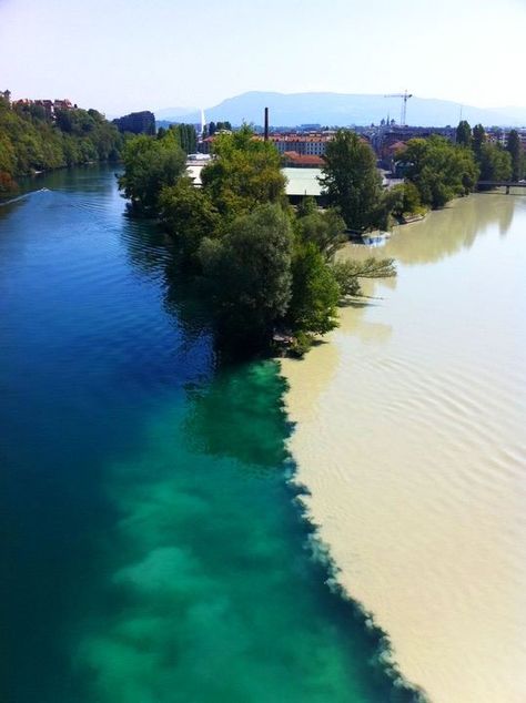 **Junction of two rivers Rhone and Arve rivers in Geneva, Switzerland. The river on the left is the Rhone, which is just exiting Lake Lehman. The river on the right is the Arve, which receives water from the many glaciers of the Chamonix valley before flowing north-west into the Rhone on the west side of Geneva, where its much higher level of silt brings forth a striking contrast between the two rivers. Incredible Pictures, Many Glacier, Two Rivers, Geneva Switzerland, Voyage Europe, Bolivia, Mykonos, Geneva, Beautiful World