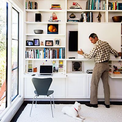 The new family room also functions as a home office, thanks to an ingenious floor-to-ceiling media center. A sliding door on the cabinets conceals the TV, and doors fold down into desks. File drawers and a printer station are concealed below—not a phone charger in sight. Printer Station, Hide Tv, Hidden Tv, Wall Bookshelves, Living Room Shelves, Room Shelves, Beautiful Living Rooms, Living Room Diy, Media Center