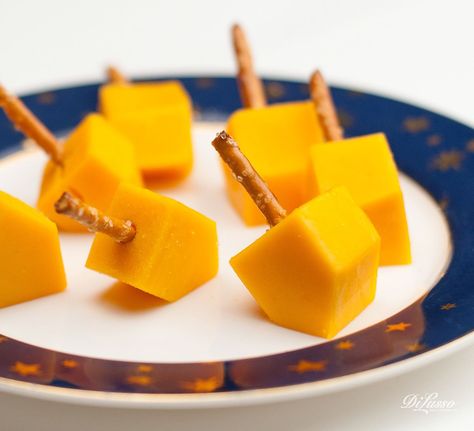 Dreidel, dreidel dreidel, I made you out of CHEESE. We firmly believe that food should be fun. Here’s a festive and easy snack the whole family can enjoy at holiday gatherings.   Directions  	Order 1” thick DI LUSSO® deli cheese slices. Mix and match cheeses. We love mild cheddar and Pepper Jack. 	Cut into cubes and trim cube ends at an angle. 	Insert pretzel sticks and serve. Hanukah Appetizers, Hannukah Party, Hanukah Menu, Hanukkah Dinner, Jewish Holiday Recipes, Hanukkah Crafts, Hanukkah Food, Chanukah Party, Chanukah Decor