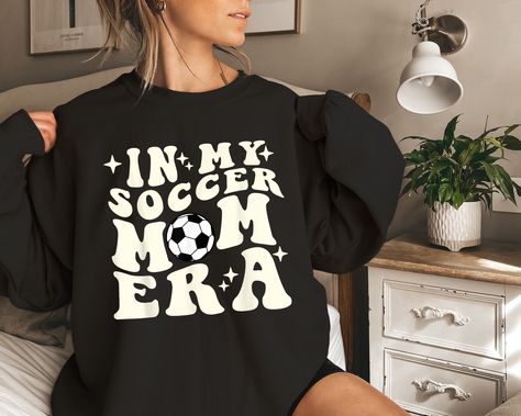 In My Soccer Mom Era Shirt, Soccer Mom Sweatshirt, Game Day Shirt, Soccer Sport Shirt, Cool Mom Club Shirt, Mom Era Sweatshirt, Mom Life Tee 👕PRODUCT INFORMATION This classic unisex jersey short sleeve tee fits like a well-loved favorite. Soft cotton and quality print make users fall in love with it over and over again. These t-shirts have-ribbed knit collars to bolster shaping. The shoulders have taping for better fit over time. Dual side seams hold the garment's shape for longer. When the design color matches the shirt color, we will automatically change the design color to white/black to make it stand out. If you want to keep the design color, please message or note for us. 🛒HOW TO ORDER 1. Check photos for sizing and color options  2. Select size and color from the drop-down menus  3 Soccer Shirts Designs, Xmas Gifts For Mom, Mom Sweater, Mom Era, Cool Mom, Festival Shirts, Moms Club, Game Day Shirts, Soccer Mom