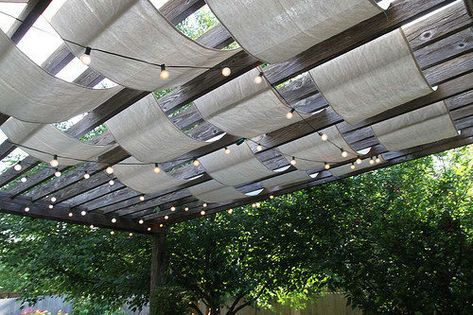 Doctor up a boring pergola by weaving wide strips of drop cloth and string lights through slats for a dreamy outdoor canopy effect. Shaded Pergola, Cloth Pergola, Ombra Pergola, Ideas Terraza, Pergola Diy, Patio Pictures, Backyard Shade, Summer Diy Projects, Pergola Swing