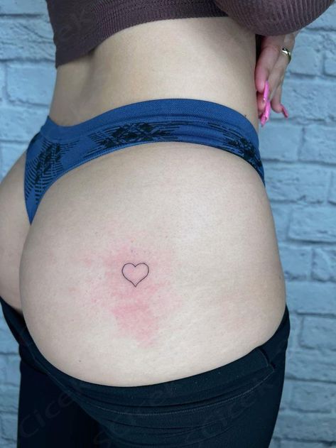 A small heart tattoo on her bottom Heart Tattoo On Buttocks, Heart On Buttcheek Tattoo, Heart Tattoo Buttcheek, Heart Tattoo On Bum Cheek, Woman Small Tattoo, Black Tattoos For Women, Tattoo On Buttcheek, Heart Tattoo Placement, Aesthetic Tattoo Design