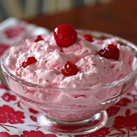 Step into a world of whimsy and delight with Pink Cherry Jello Fluff, a dessert that's as fun to make as it is to eat. This light and airy treat combines the sweet tanginess of cherry Jello with creamy whipped topping and fluffy marshmallows, all punctuated by the juicy burst of cherry pieces. Perfect for gatherings, celebrations, or as a cheerful pick-me-up, this dessert not only captivates with its playful pink hue but also enchants with its blend of textures and flavors. Easy to prepare and i Pink Cherry Jello Fluff, Pink Fluff Recipe, Jello Yogurt Fluff, Cherry Jello Fluff, Jello Mouse, Pink Jello Salad, Pink Fluff Salad, Cherry Jello Recipes, Creamy Jello