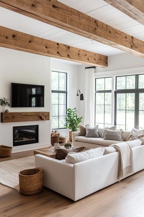 Modern farmhouse interior living room with rustic beams modern furniture electric fireplace. Get inspired by all of these modern farmhouses that blend rustic charm with sleek, contemporary design for a cozy yet sophisticated home. Farm Home Design, Simple Modern Home Interior, Farmhouse Interior Ideas Living Room, Living Room Designs Ranch House, Modern Farmhouse Ceiling Beams, Luxe Farmhouse Living Room, Modern Ranch Home Interior, House West Design, Farmhouse Style Family Room