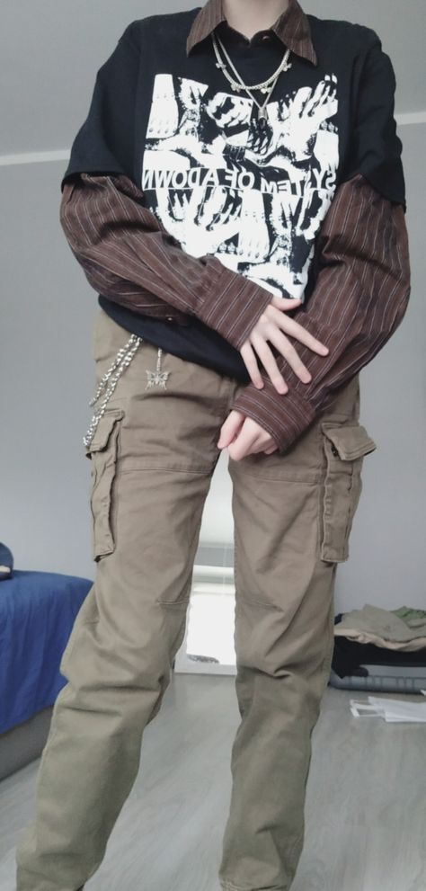 boy in khaki green cargo pants, a brown striped button up shirt and a black tshirt layered on top, accessorized with chain jewelery Black Transmasc Fashion, Alternative Academia Fashion, Indie Grunge Outfits Men, Alt Dark Academia Outfits, Gender Neutral Alt Fashion, Alternative Clothing Men, Dark Autumn Outfits Men, Indie Outfits Male, Postapocalyptic Style Men