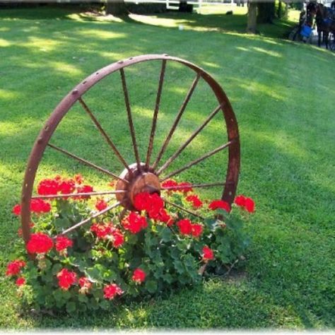 Wagon wheel.  I've seen these at Garden Ridge.  Maybe I could doe something like this near the fence or driveway. Roda Gerobak, Cheap Landscaping Ideas, Spring Decoration, Have Inspiration, Garden Yard Ideas, Wagon Wheel, Rustic Gardens, Country Gardening, The Grass