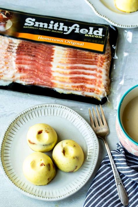 3 Instant Pot Egg Bites on a white plate with a fork, cup of tea, striped napkin, and package of bacon in the background all over a white backdrop Egg Bites With Bacon, Instant Pot Egg Bites, Grab And Go Breakfast, Gouda Cheese, Egg Bites, White Plate, Instapot Recipes, White Backdrop, Taste Testing