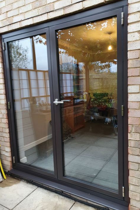 Newly fitted slimline black double glazed aluminium french doors leading out on to stone patio in Buckinghamshire. View into dining room with wooden dresser. External Glass Doors, Brown Interior Doors, Kitchen Patio Doors, Screened Deck, French Doors Patio Exterior, Black French Doors, Modern Patio Doors, Double Patio Doors, Aluminium French Doors