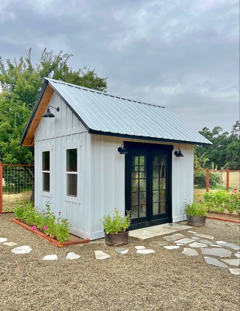 More than a shed, less than a house… sketched this 12x10’ design a year ago and built it for $3,580 in materials. Almost 12’ vaulted ceiling. The french doors were reclaimed from an old mining town building. Majority of supplies, including windows, purchased at Lowe’s. Poured the concrete slab ourselves. Working on the interior now. Small Backyard Buildings, White And Black Shed Exterior, Mini House Shed, Shed With A Porch, White Shed Black Door, Black And White Shed Exterior, Farmhouse Shed Exterior, White Shed With Black Trim, Large Garden Shed