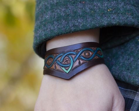 This ladie's bracelet was created especially for Celtic lovers! The pattern uses Celtic knots, triskele and shamrocks. The leather bracelet looks elegant on a woman's hand. Perfect for casual wear and fantasy outfits. Blacksmith Hammer, Celtic Knot Bracelet, Fantasy Outfits, Celtic Bracelet, Ladies Bracelet, Handmade Leather Bracelets, Celtic Style, Celtic Design, Celtic Knots