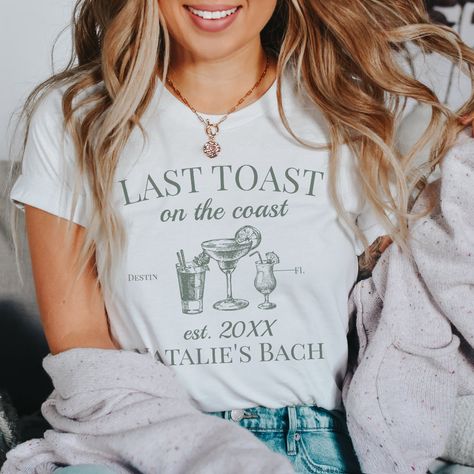 Celebrate the coastal charm with our Last Toast On The Coast Beach Bachelorette Party T-Shirt – the epitome of luxury and style for your beach bachelorette. This custom shirt is more than just fashionable attire; it's a symbol of personalized luxury, making it perfect for your last toast on the coast.  Featuring the phrase "Last Toast On The Coast," this shirt sets the tone for a memorable beach bachelorette party. The personalized luxury bachelorette design, combined with sage green social club Beach Bachelorette Party Shirts, Club Bachelorette, Luxury Bachelorette, Last Toast On The Coast, Toast On The Coast, Beach Bachelorette Party, Custom Bachelorette, Bridal Party Attire, Bachelorette Party Beach