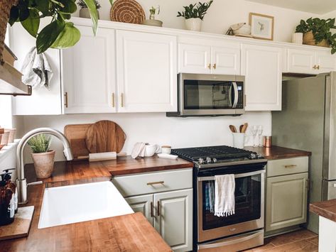 Green And White Kitchen Cabinets Butcher Block, White Cabinet Boho Kitchen, Plants Over Cabinets, Sage Bottom Cabinets White Top, Low Cabinets In Kitchen, Two Tone Cabinets With Butcher Block, Olive Green And White Kitchen Cabinets, Off White And Green Kitchen Cabinets, White And Butcher Block Kitchen