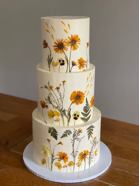 3 tiered buttercream wedding cake decorated with pressed flowers Yellow Flowers Wedding Cake, Wedding Cake With Pressed Flowers, Wedding Cake Wild Flowers, Pressed Flowers Wedding Cake, Wedding Cake Pressed Flowers, Pressed Flower Wedding Cake, Marigold Wedding Cake, Wild Flower Wedding Cake, Pressed Flower Cake