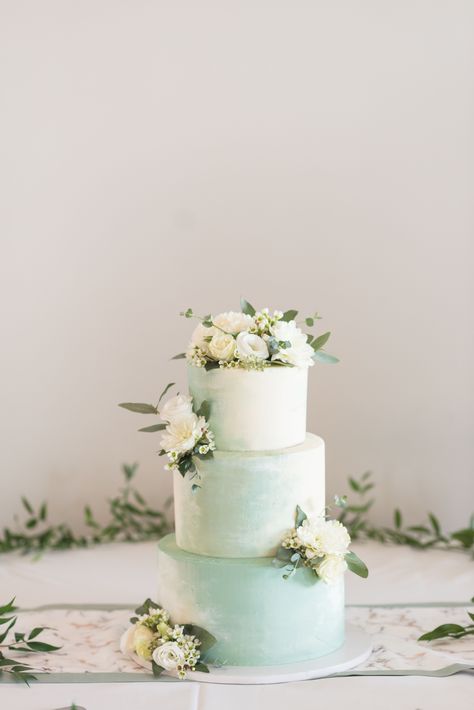 Simple and elegant white and mint green wedding cake. 3 tier wedding cake with white flowers, babys breath, and green foilage. Nashville wedding photography by Mandy Liz. Mint green aesthetic for a wedding. Faded watercolor wedding cake painted design.   #NashvilleWeddingPhotographer #NashvilleWeddingVenue #weddingpictures #weddinginspiration #weddingcake Wedding Cake Mint Green, Pastel Green Wedding Cake, Mint Green Cake Design, Wedding Cake Painted, Wedding Cake Watercolor, White And Green Wedding Cake, Green And White Wedding Cake, Wedding Cake With White Flowers, Mint Green Cake