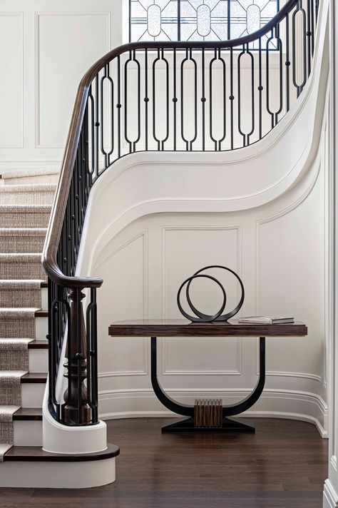 Oftentimes, it is the railing that determines the character of a stairway as a transitional space. Here, we formulated a detailed modern response to the classic French iron railing. Its elegant ellipses and sweeping curves echo the structured window and sleek side table.⁠ ⁠ Design: @DouglasDesign⁠Studio Architecture: @LorneRoseArch⁠ #stairs #stairwell #staircase #hallway #handrail #railings #iron #grandstaircase #douglasdesignstudio⁠ New Classic Stairs Design, Outside Stairs Railing Ideas, Bilevel Staircase Ideas, Iron Balusters Stairs Modern, French Iron Railing, Modern Classic Stairs, Staircase Design Luxury Classic, French Country Stair Railing Ideas, Staircase Design Classic