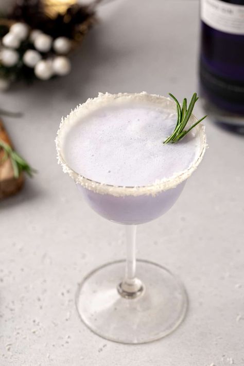 The Snowy Day is a delicious winter gin cocktail featuring Empress Gin, cream of coconut and lime. This winter gin cocktail is the perfect drink to enjoy on a snowy evening. The shredded coconut rim and foam layer on top give it a snowy feel and a ton of delicious flavor! This is a great Christmas cocktail, and its beautiful purple color makes it great as a Valentine's Day cocktail too. Gin Coconut Cocktails, Empress Gin Winter Cocktail, Christmas Cocktails Gin, Empress Gin Cocktail, Empress Gin, The Snowy Day, Christmas Gin, Snowy Evening, Cream Of Coconut