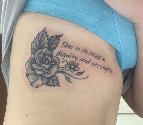 “She is clothed in dignity and strength” Strength And Dignity Tattoo, Womans Strength Tattoo, She Is Clothed In Strength And Dignity Tattoo, Strength And Dignity Are Her Clothing, She Is Clothed In Strength And Dignity, She Is Clothed, Rib Tattoo, Flower Tattoo, Piercings