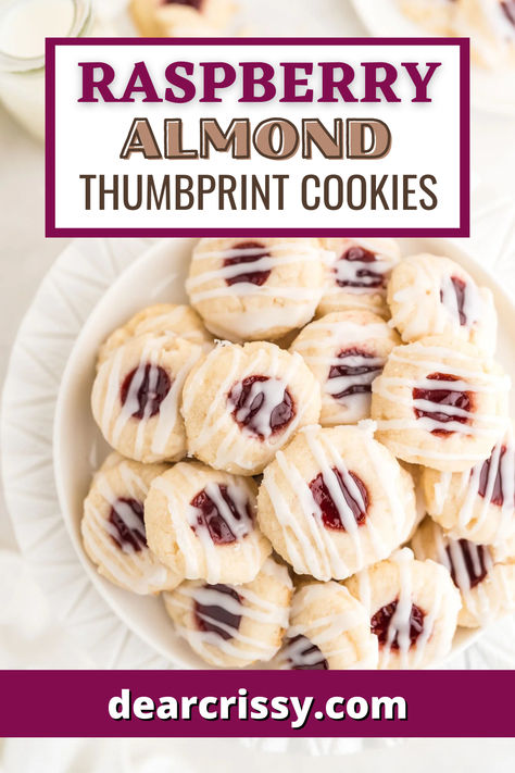 Indulge in the delightful fusion of buttery sweetness and tart raspberry goodness with these Raspberry Almond Thumbprint Cookies. Each bite features a tender, almond-infused cookie, perfectly cradling luscious raspberry jam. Topped with a light glaze, they offer a stunning presentation that will impress at any gathering. Simple yet elegant, these cookies are the perfect treat to share or savor yourself. Raspberry Almond Thumbprint Cookies, Best Thumbprint Cookies, Almond Thumbprint Cookies, Cookies Thumbprint, Raspberry Thumbprint Cookies, Dessert Christmas, Jam Thumbprint Cookies, Almond Shortbread, Almond Shortbread Cookies