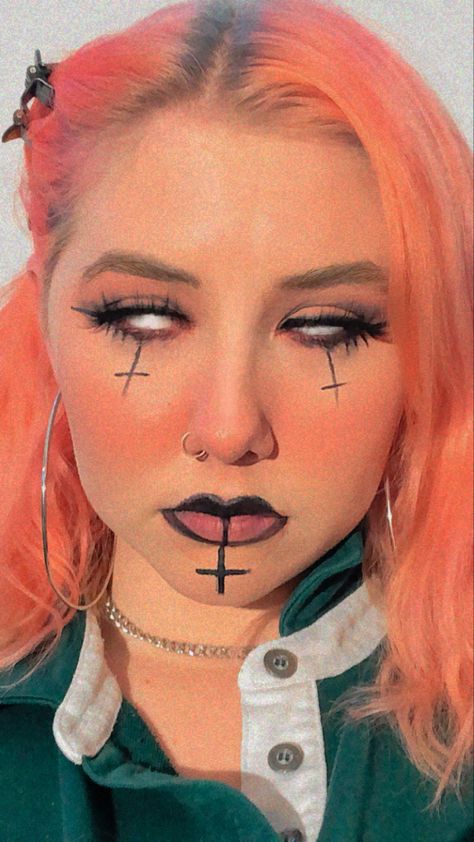 Person with pink hair and alternative makeup with pink blush, eyeshadow, eyeliner, upside down crosses. Cross Makeup Look, Cross Eyeliner, Satanic Makeup, Goth Eyeliner For Almond Eyes, Cross Makeup, Eyeliner Styles For Hooded Eyes Goth, Goth Cross Makeup, Crazy Eyeliner Goth, Upside Down Cross