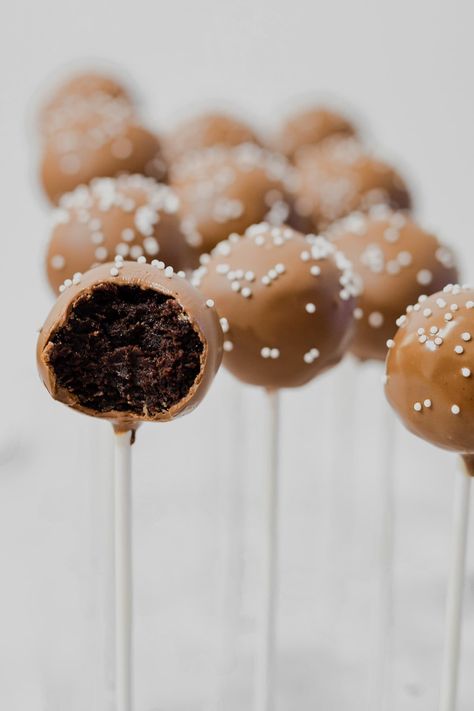 starbucks copycat chocolate coated chocolate cake pops with one bitten in half to show chocolate cake ball middle Cake Pops Recipe Chocolate, Chocolate Cake Pop Recipe, Cake Pops From Scratch, Dairy Free Cream Cheese Icing, Cake Pops Starbucks, Chocolate Cake And Frosting, Easy Cake Pops, Chocolate Cake Pops Recipe, Chocolate Cake Pop