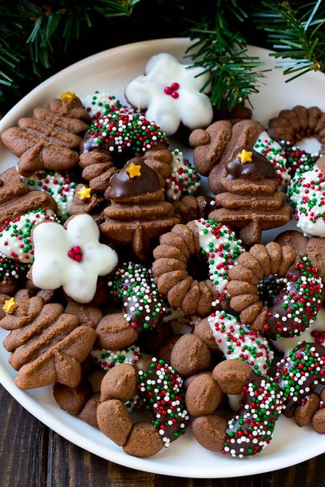 A plate of chocolate spritz cookies decorated with chocolate and sprinkles. Spritz Cookies Christmas, Chocolate Spritz Cookies, Cookie Press Recipes, بيتي فور, Spritz Cookie Recipe, Easy Christmas Cookie Recipes, Spritz Cookies, Cookie Press, Buttery Cookies