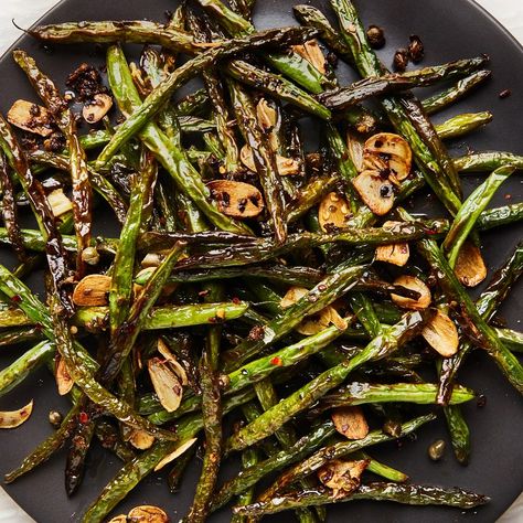 Inspired by satly-crunchy Sichuan dry-fried string beans (gan bian si ji dou), these green beans are shriveled and browned into delicious submission before receiving a flavor bomb of garlic, red pepper flakes, and chopped capers at the very end. Resist the urge to stir the beans around in the pan, and let them take on color like you would ground meat. Patience is essential here. Blistered Green Beans, Garlicky Green Beans, French Green Beans, Cooking Green Beans, Garlic Green Beans, 5 Ingredient Recipes, Passover Recipes, Fresh Green Beans, Green Bean Recipes