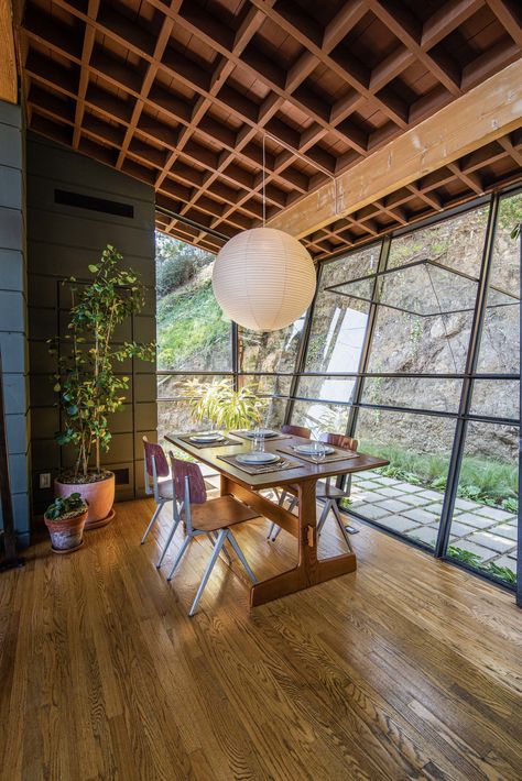 The slanted floor-to-ceiling glass walls were designed to mimic the surrounding slope. A Quincy Jones, Box Beam Ceiling, Quincy Jones, Floating Staircase, Laurel Canyon, Glass Facades, Los Angeles Homes, Brick Fireplace, Ceiling Beams