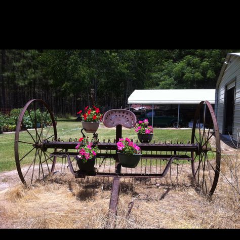 Would love to have an old hay rake for my yard. There is one for sale now I just need to convince the Hubby. I have got to find a way to mark our driveway so people can find the farm Antique Farm Equipment Landscape, Antique Hay Rake Ideas, Old Farm Equipment Decor Yards, Jupiter's Legacy, Farm Landscaping, Backyard Creations, Garden Wagon, Wagon Wheels, Old Farm Equipment