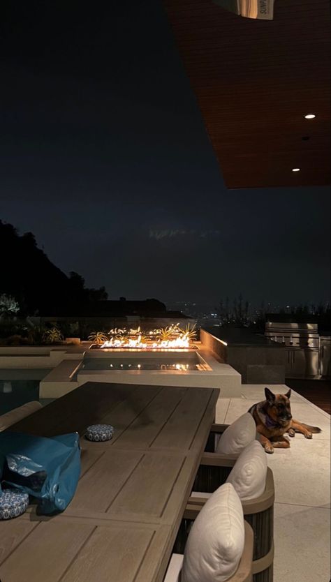 Los Angeles cozy evening outside with a german shepherd , infinity pool view over DTLA cream pillows earth tones interior design outdoor design fireplace California n California Mansion Aesthetic, Penthouse In Los Angeles, Los Angeles House View, Los Angeles Houses Aesthetic, Los Angeles Aesthetic House, Los Angeles House Interior, Los Angeles Mansion Aesthetic, Los Angeles Luxury Lifestyle, Los Angeles Penthouse Luxury