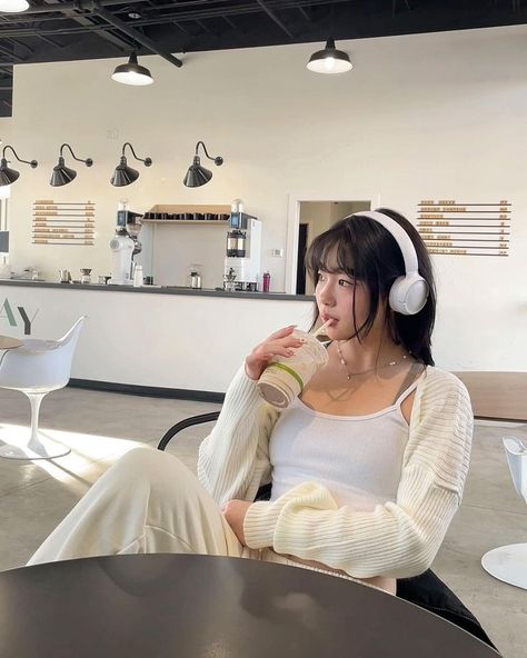 A girl in a monochrome white outfit sits in a cafe wearing headphones. Chai Latte, Selfie Poses, Link In Bio, Headphones, Sweatpants, Cafe, Tracksuit Bottoms