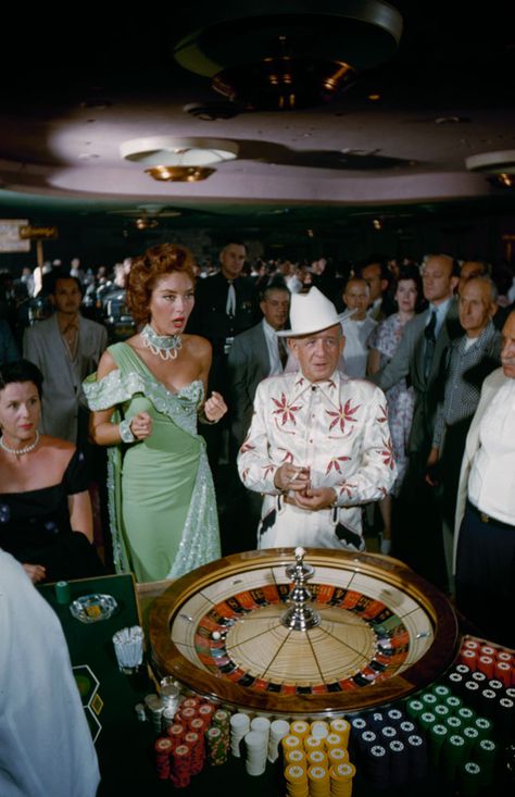 1955 fashion style found photo las vegas gambling roulette table woman lady mint green blue evening gown man in white suit cowboy hat 50s vintage Las Vegas 1960s, 60s Casino Fashion, Rat Pack Las Vegas, Old School Vegas Fashion, Las Vegas 1980s, Vintage Las Vegas Showgirl, Gambling Aesthetic Vintage, Casino Night Aesthetic, 60s Casino