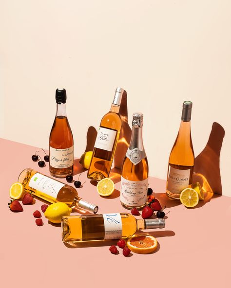 Six wine bottles are scattered on a pink and cream background, some laying down while others stand or lean. The fruit placed beside including strawberries, raspberries, lemons and cherries represent the tasting notes of the wines. Beverage Photography Ideas, Wine Bottle Photography, Bottle Shoot, Beverage Photography, Still Life Pictures, Food Photoshoot, Wine Photography, Fruit Wine, Styling Photography