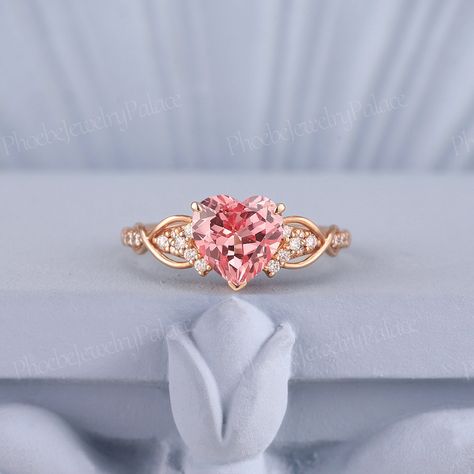 Unique Peach Pink Sapphire Engagement Ring 14K Gold Heart Love Rings for Women Vintage Moissanite Cluster Wedding Ring Custom Handmade Gift PRODUCT SUMMARY Metal Type: Solid yellow, white or rose gold,10k/14k/18k gold. Size: All sizes are available, contact me if they do not contain the size you want in the drop-down menu. ☪☪Engagement ring ⚜Center Stone - Lab grown Peach Pink Sapphire Cut - Heart Shaped Size - 7x7mm ⚜Side Stone - Moissanite/Natural Diamonds Cut - Round  Weight - 0.116ct Clarity Pink Gem Engagement Ring, Rings Engagement Heart, Coquette Engagement Ring, Unique Pink Engagement Rings, Pink Heart Cut Ring For Wedding, Pink Rings Engagement, Pink Gold Heart-shaped Wedding Ring, Elegant Pink Heart-shaped Ring, Elegant Pink Sapphire Heart Cut Rings