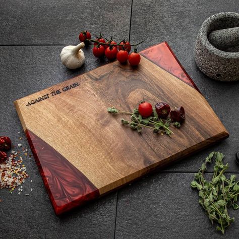 Beautiful crimson red pearl resin and wood chopping boardAll boards are unique and one of a kind so please note that whilst I can offer close matches there will be variations in wood grain, size, and pattern within the resin.Outstanding pearl effect crimson red and deep walnut chopping boar. Hand made and finished with “oldies oil” food safe natural wax/oil. This piece is such a stunning board which will brighten up any kitchen. The natural effect this resin had during the curing process really Unique Resin Ideas, Wooden Kitchen Board, Dinner On The Go, Diy Resin Table, Pearl Resin, Wood Resin Table, Wood Chopping, Wooden Chopping Boards, Red Pearl