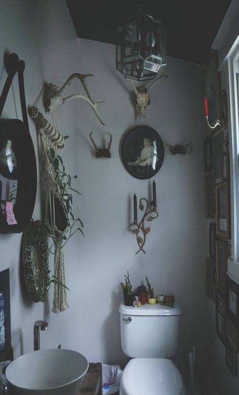 Gothic half bath with deer antlers and vintage art gallery wall #taxidermy #bathroom #gothicmaximalist #maximalist #goth Goth Half Bathroom, Small Witchy Bathroom, Vintage Gothic Kitchen, Small Gothic Bathroom, Goth Bathroom Aesthetic, Gothic Half Bath, Small Gothic Bathroom Ideas, Country Goth Decor, Goth Restroom