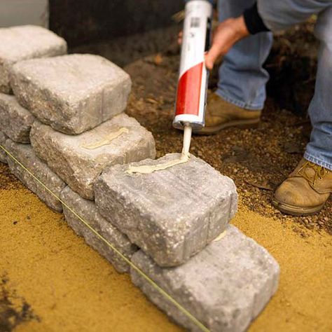 Some retaining-wall blocks have locking mechanisms that allow them to be built to about 4 feet tall without extra engineering. Because we used tumbled blocks with no locking mechanisms, we used a construction adhesive on alternate courses. Remember, with locking blocks, you can remove blocks and start over if you make a mistake. But adhesive permanently bonds blocks, so work carefully./ Exterior Steps, Retaining Wall Steps, Diy Retaining Wall, Backyard Retaining Walls, Retaining Wall Blocks, Building A Retaining Wall, Sloped Yard, Entry Stairs, Landscaping Retaining Walls