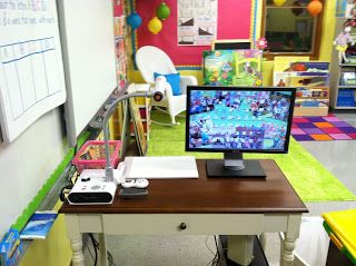 Keeping your supplies next to your Smartboard can be a CHALLENGE. Check out how this teacher has set up a permanent station for her document camera and projector remotes. The little drawer is great for whiteboard markers and other supplies you need within reach. Modern Teacher, Teaching Organization, Classroom Layout, Class Organization, Classroom Organisation, Teacher Desk, First Grade Classroom, Organization Decor, Teacher Organization