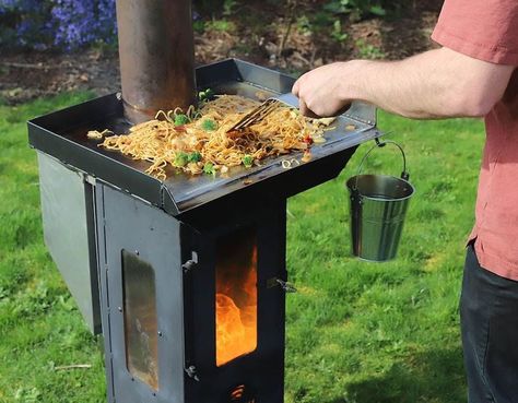 A homeowner cooks stir fry atop his Lil Timber Patio Heater non-electric pellet stove in his backyard Pellet Stove Water Heater, Pellet Stove Platform, Timber Patio, Non Electric Pellet Stove, Portable Electric Stove, Pellet Heater, Us Stove Company, Wood Stove Heater, Out Door Heater