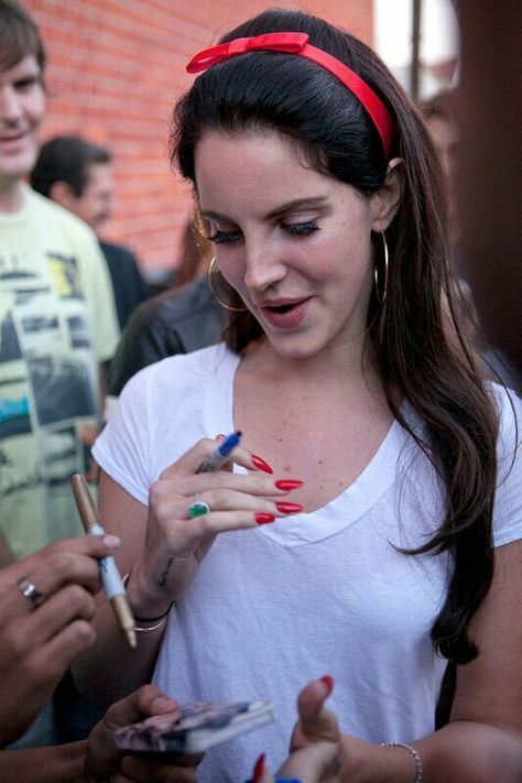 Lana Del Rey white t-shirt long red fake nails red hair ribbon bow/headband long dark brown straight hair eyes closed laughing Red Hair Ribbon, Zoella Hair, Lana Rey, Elizabeth Grant, Zoella, Santa Monica California, Nails Red, Lana Del Ray, Hair Ribbon