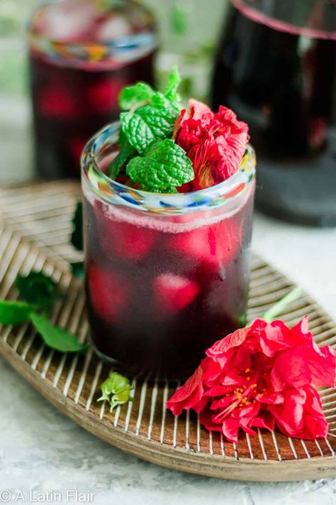 Agua de Jamaica (Homemade Hibiscus Iced Tea). Sweet. Tart. Refreshing. Full of Mexican tradition. The most popular Agua Fresca in Mexico! Only 3 ingredients and 15 minutes to make! #alatinflair #aguadejamaica #hibiscustea alatinflair.com Agua Fresca Jamaica, Homemade Agua Fresca, Flowers Mexico, Hibiscus Iced Tea, Agua Fresca Recipe, Jamaica Food, Kid Friendly Drinks, Dried Hibiscus Flowers, Mexican Drinks