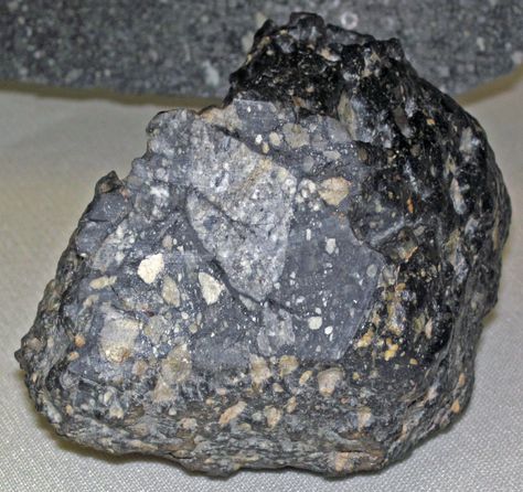 Lunaite - lunar breccia (NW Africa 8586 Meteorite).This Moon rock has been classified as a "lunar feldspathic fragmental breccia": a poor lithologic label.All breccias have fragments so "fragmental breccia" is uninformative, unnecessary, & redundant.Also the dominant clast type isn't feldspar, it's anorthosite, a coarsely-crystalline textured, intrusive igneous rock dominated by the mineral anorthite.Some clasts are basalt from lunar lowlands.The anorthosite clasts come from the lunar highlands. Lunar Meteorite, Geology Rocks, Moon Rock, Rock Minerals, Native American Artifacts, Space Rock, Rock Collection, Mineral Stone, Types Of Gemstones