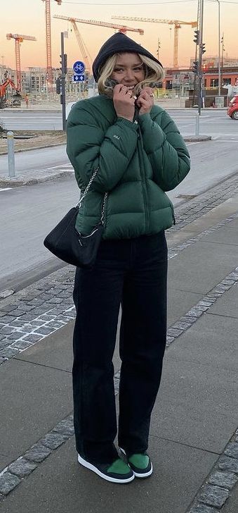 a green puffer jacket with black pants, a black shoulder bag, and black and green air jordan 1's Puffer Jacket Outfit Aesthetic, Outfits With Puffer Jackets, Green Puffer Jacket Outfit, Puffer Jacket Aesthetic, North Face Puffer Jacket Outfit, Puffer Jacket Outfits, Green Jacket Outfit, Puffer Outfit, Puffer Jacket Outfit