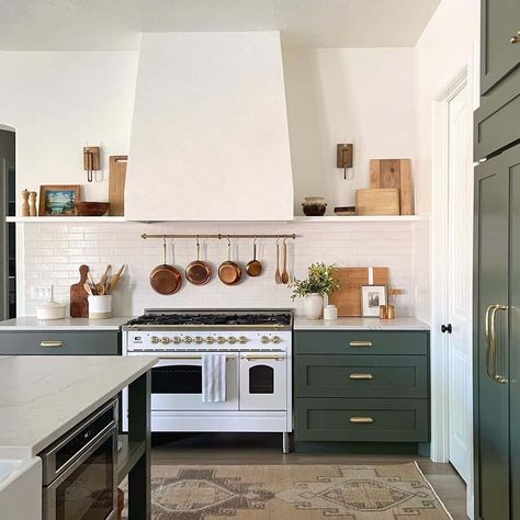 White and gold gas range with white range hood is fitted between sage green kitchen cabinets topped by a white countertop. The cabinets are finished with gold hardware and a white subway tile backsplash. Green Kitchen Island, Green Kitchen Designs, Dark Green Kitchen, Sage Green Kitchen, Green Kitchen Cabinets, Rustic Modern Kitchen, Green Cabinets, White Countertops, House Renovation