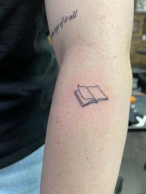 Book Tattoo Minimal, Fine Line Typewriter Tattoo, Simple Tattoos For Book Lovers, Book Tiny Tattoo, Closed Book Tattoo, Literature Tattoo Ideas, Book Outline Tattoo, Book Tattoo Simple, Literature Tattoos Minimalist