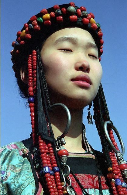 A Buryat girl from the Buryatia Republic, Russia. The Buryat people are descended from various Siberian and Mongolic peoples that inhabited the Lake Baikal Region. Then in the 13th century the Mongolians came up and subjugated the various Buryat tribes (Bulgachin, Heremchin). The name "Buriyad" is mentioned as one of the forest people for the first time in The Secret History of the Mongols (possibly 1240). . Lake Baikal, Poses References, People Of The World, World Cultures, Interesting Faces, 인물 사진, Mongolia, Traditional Dress, Anthropology